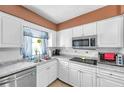 Bright kitchen with white cabinetry, stainless steel appliances, and tile backsplash at 3119 Roberta St, Largo, FL 33771
