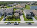 A beautiful aerial view of the home features a lake, green lawns, and manicured landscaping at 3326 Acacia Bay Ave, Wesley Chapel, FL 33543