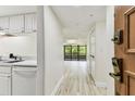 Inviting entry with views of living area and balcony, light wood-look floors, and modern front door hardware at 36750 Us 19 N # 20311, Palm Harbor, FL 34684
