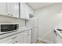 Bright kitchen with white cabinets, and compact appliances maximizing the counter space in a streamlined layout at 36750 Us 19 N # 20311, Palm Harbor, FL 34684