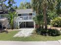 Charming home with a light blue exterior, white railings, and lush landscaping at 401 Pennsylvania Ave, Crystal Beach, FL 34681