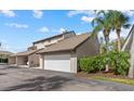 Attached garage with driveway and tropical landscaping around the exterior of the building at 4777 Duhme Rd # 1D, St Petersburg, FL 33708