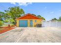 Detached garage with a blue door and ample parking space, featuring a well-maintained exterior at 5236 Madison St, New Port Richey, FL 34652