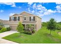Charming two-story home featuring a well-manicured lawn, inviting entrance, and attached two car garage at 5430 Thistle Field Ct, Wesley Chapel, FL 33545