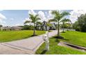 Paved driveway leads to a pristine white home framed by palm trees at 7725 235Th E St, Myakka City, FL 34251