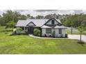 Charming home boasts a metal roof, verdant lawn, and a basketball hoop at 7725 235Th E St, Myakka City, FL 34251