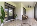 Covered outdoor patio featuring tile floors, ceiling fan and comfortable seating at 7725 235Th E St, Myakka City, FL 34251