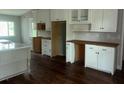 Spacious kitchen with white cabinetry, dark floors, and work desk at 8033 55Th E St, Palmetto, FL 34221