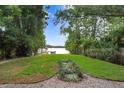 Lush backyard leading to the lake, framed by bamboo and verdant trees, enhancing the property's natural appeal at 8903 Donna Lu Dr, Odessa, FL 33556