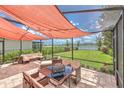 Screened patio featuring an outdoor dining table set and peaceful lake views at 10081 Sage Creek Dr, Sun City Center, FL 33573