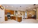 Open-concept kitchen with stainless steel appliances, granite countertops, and seamless flow to the living area at 10513 Palm Cove Ave, Tampa, FL 33647
