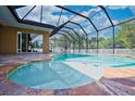 A luxurious screened-in pool area featuring a beautiful pool with a spa and ample patio space at 10513 Palm Cove Ave, Tampa, FL 33647