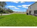 Spacious backyard with a well-manicured lawn and a white fence, perfect for outdoor activities at 10823 Trailing Vine Dr, Tampa, FL 33610
