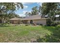 Charming single-story home with a well-manicured lawn and mature trees shading the house at 10902 Bent Tree Pl, Tampa, FL 33618