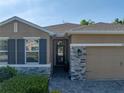 Inviting home entrance with stone accents, a brick pathway, and well-maintained landscaping at 12492 Eastpointe Dr, Dade City, FL 33525