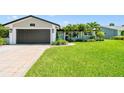 Beautifully landscaped home with mature palms and a well-manicured lawn and a two-car garage at 1432 50Th Ne Ave, St Petersburg, FL 33703