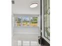Light-filled foyer with a view of the front yard and a decorative glass front door and marbled floor at 1905 E Broad St, Tampa, FL 33610
