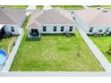 Aerial view of backyard with white fence, covered patio area and well maintained grassy area at 191 Brofield St, Brooksville, FL 34604