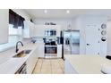 Modern kitchen with stainless steel appliances, white countertops, stylish cabinetry, and tile floors at 191 Brofield St, Brooksville, FL 34604