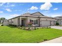 Single-story home features a well-manicured lawn and an inviting front entrance with a welcome sign at 20108 Stone Pine Cir, Lutz, FL 33558