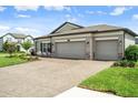 The home features a large three-car garage and brick paver driveway at 20108 Stone Pine Cir, Lutz, FL 33558