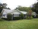 Traditional single-story home featuring a well-manicured lawn, decorative bushes, and black shutters at 2143 Wrens Way, Clearwater, FL 33764