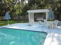 Poolside lounge area featuring a covered patio with comfortable seating, ideal for outdoor relaxation and entertaining at 2143 Wrens Way, Clearwater, FL 33764