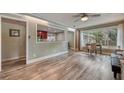 Bright living room features wood floors, a ceiling fan, and a pass-through view to the kitchen at 2316 Lancaster Dr, Clearwater, FL 33764
