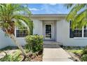 Inviting front entrance with a secure screen door and lush tropical landscaping at 2719 Wilder Trace Ct, Plant City, FL 33566