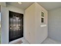 The front door is black with a welcome mat; it also has a window and gray neutral paint at 3186 Oyster Cove St, Wimauma, FL 33598