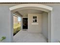 Inviting front porch featuring neutral gray walls, a black front door, and a welcome mat at 3186 Oyster Cove St, Wimauma, FL 33598