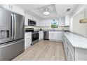 Modern kitchen featuring stainless steel appliances, granite countertops, and white cabinetry at 350 Kentucky Ave, Crystal Beach, FL 34681