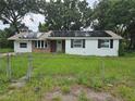Charming home featuring white painted brick, modern solar panels, and a cozy front yard at 3614 E Grove St, Tampa, FL 33610