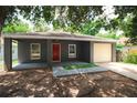 Inviting exterior with red door, complemented by a freshly poured concrete porch and driveway, plus a one-car garage at 3632 E Comanche Ave, Tampa, FL 33610