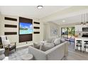Open-concept living area with modern decor, gray sectional, and view of the kitchen at 4379 Porpoise Se Dr, St Petersburg, FL 33705