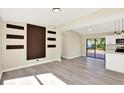 Open-concept living area featuring modern flooring, a statement wall, and sliding glass doors to the backyard at 4379 Porpoise Se Dr, St Petersburg, FL 33705