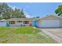 Inviting single-Gathering home features a two-car garage and an eye-catching blue front door at 540 Firefly Ln, Apollo Beach, FL 33572