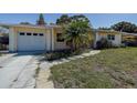 View of the home's exterior, driveway, and front yard with mature trees at 5483 37Th N Ave, St Petersburg, FL 33710