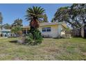Side view of the one-story home with lawn, plants, and a fenced yard at 5483 37Th N Ave, St Petersburg, FL 33710