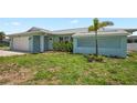 Charming single-story home with a two-car garage and a tropical palm tree at 7322 Ellis Ln, Port Charlotte, FL 33981