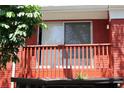 Close up of a red balcony with white framed sliding glass doors and a partial view of foliage at 8220 12Th N Way # H, St Petersburg, FL 33702