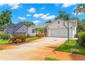 Exterior home view showcasing a driveway with basketball hoop, lawn with garden bed, and nearby houses at 859 Harbor Hill Dr, Safety Harbor, FL 34695