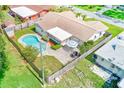 Aerial view of the fenced backyard featuring a sparkling pool, patio area, and mature landscaping at 11082 90Th Ter, Seminole, FL 33772