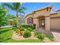 Close up of a well maintained front yard with colorful landscaping and a brick-paved driveway at 1242 Windy Bay Shl, Tarpon Springs, FL 34689
