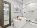 Modern bathroom featuring a standalone tub, a glass-enclosed shower, and neutral gray paint at 1340 Bayshore Blvd # 502, Dunedin, FL 34698