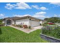 Well-manicured front lawn and landscaping around the home's exterior, featuring a two car garage at 1914 Sassafras Dr, Wesley Chapel, FL 33543