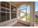 View from the screened lanai, showcasing brick flooring and views of the home's landscaping at 1914 Sassafras Dr, Wesley Chapel, FL 33543
