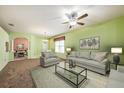 Bright living room with plush seating, decorative ceiling fan, and an open archway to the dining area at 1914 Sassafras Dr, Wesley Chapel, FL 33543