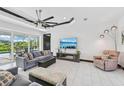 Bright living room features modern furnishings, a large ceiling fan, and sliding glass doors leading to outdoor living at 200 Eppinger Dr, Port Charlotte, FL 33953