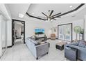 Open-concept living area showcasing stylish furniture, a ceiling fan, and doors leading to other rooms and outdoor spaces at 200 Eppinger Dr, Port Charlotte, FL 33953